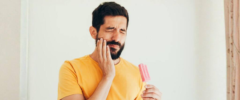 Man with tooth sensitivity to ice cream.